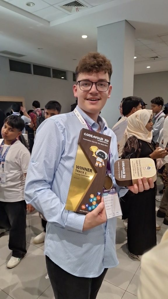 Ahmed Gušo holding awards from the Codeavour robotics competition for kids